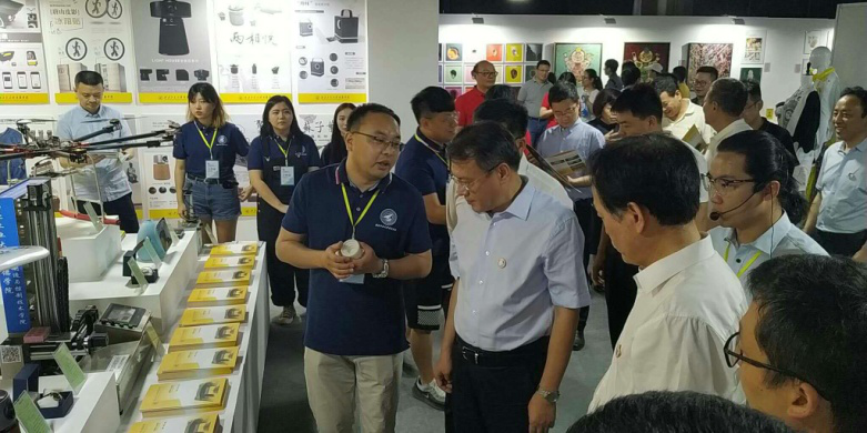 西安市委常委、副市長高杲在青博會(huì)聽取明德學(xué)院師生講解設(shè)計(jì)作品